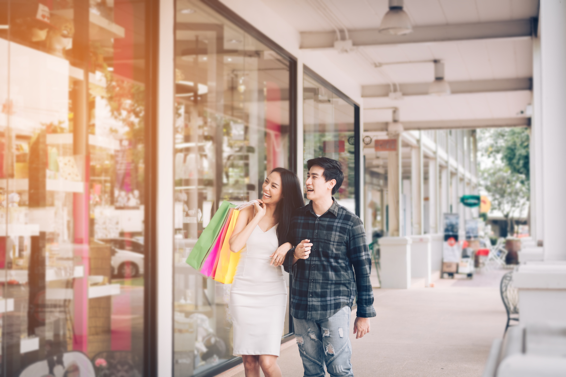 Young asian couple enjoy walking shopping at outlet mall.
